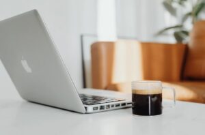 Aufgeklappter Laptop in ruhiger Atmosphäre mit Heißgetränk the Slow Edit