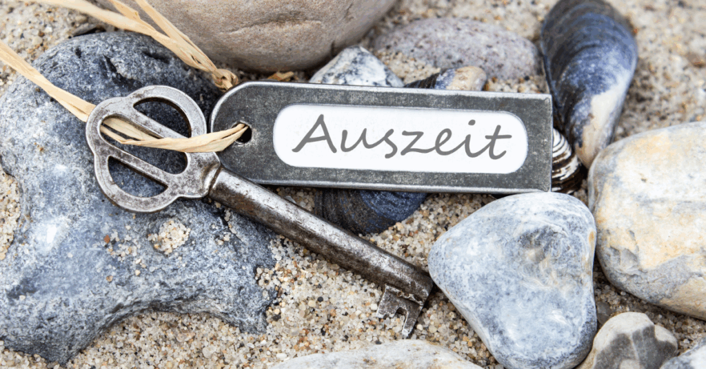 Schlüssel liegt im Sand zwischen Steinen – Symbol für kreative Auszeit und innere Ruhe