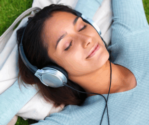 Frau die sich mit Kopfhörern auf den Ohren entspannt