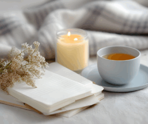Gemütliche Winterlesestunde: Tasse Tee, geöffnetes Buch und Strickdecke